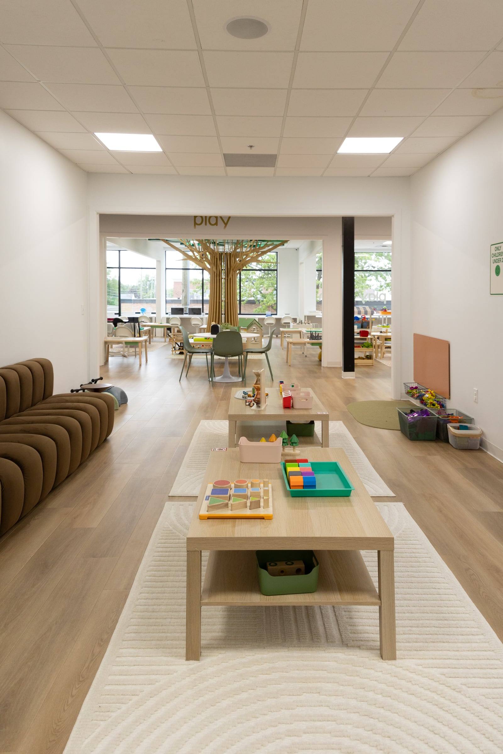 A long play table and a cozy sofa leading to the tree room