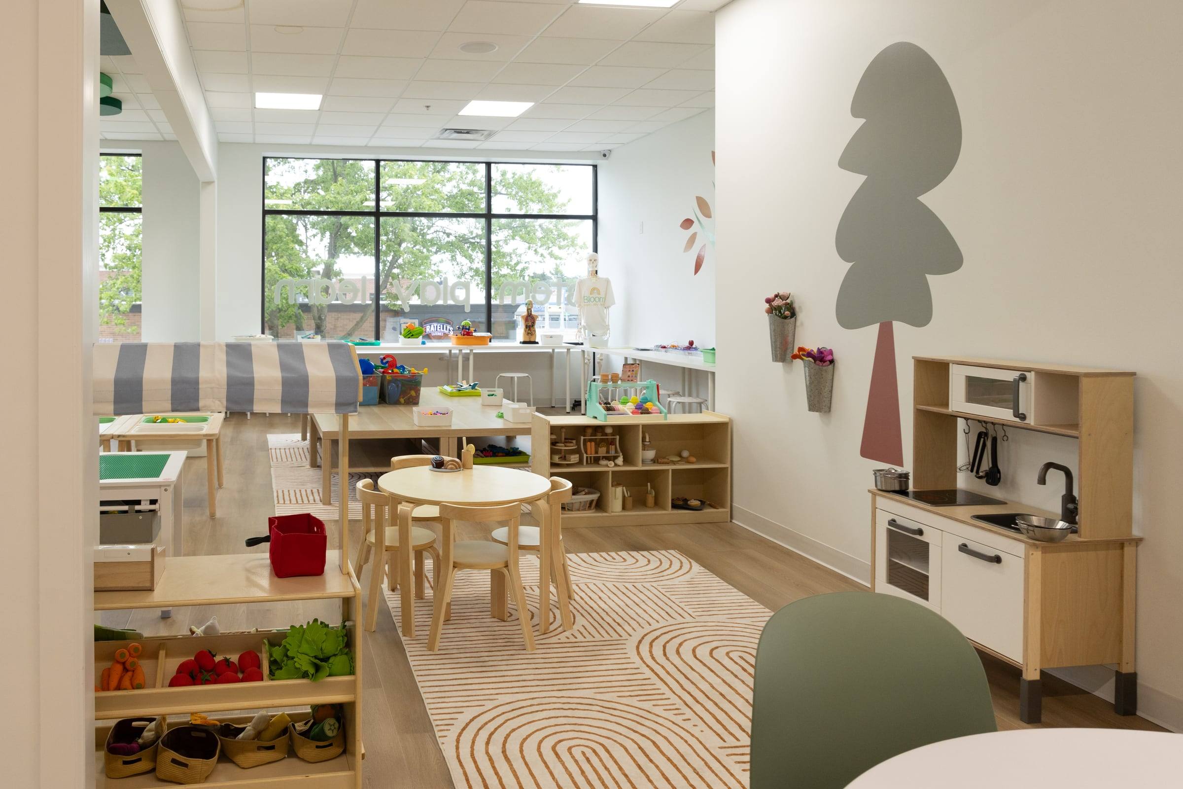 The play kitchen corner with a small table and chairs