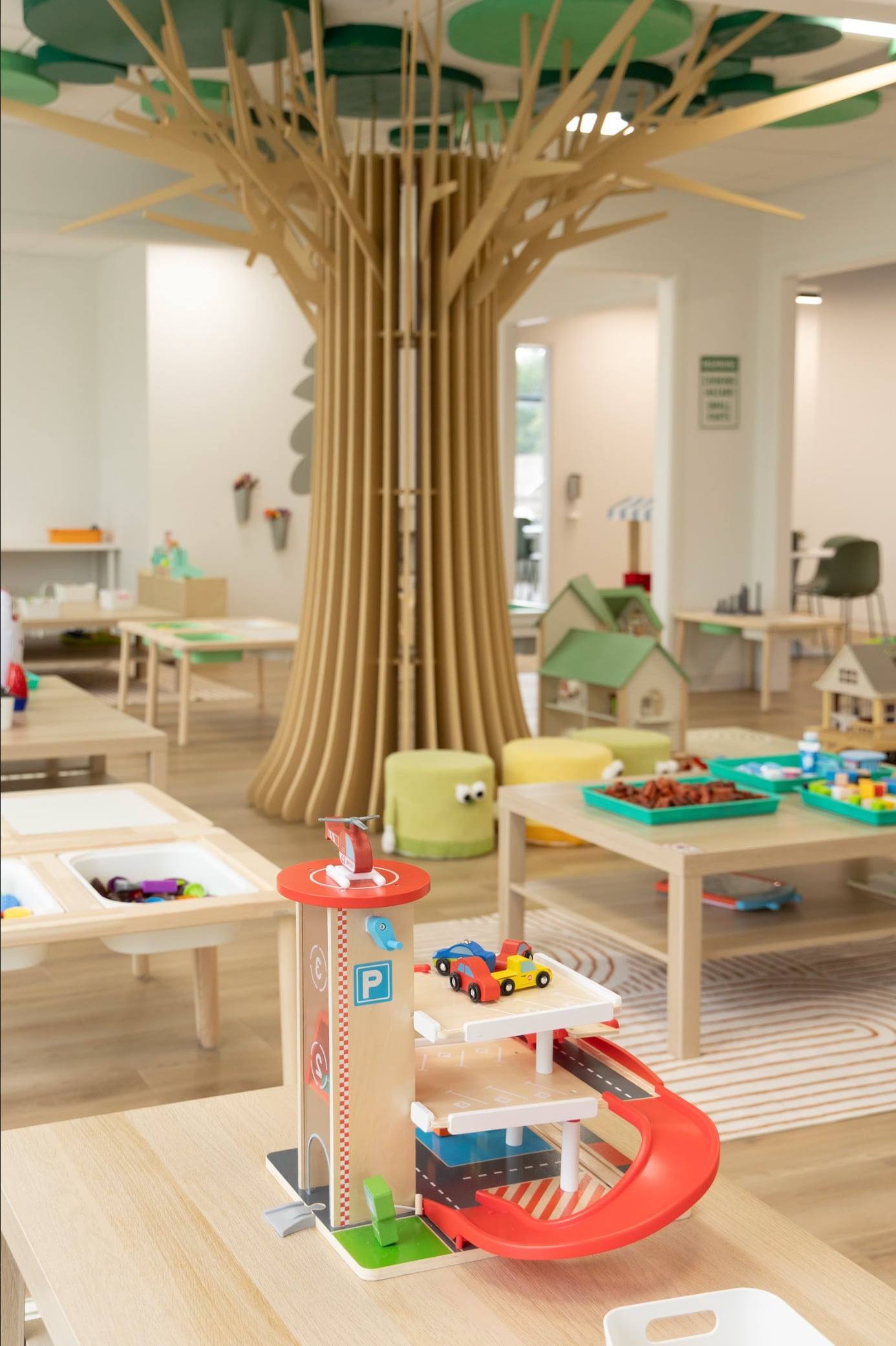 The big wooden tree at the heart of Bloom's play room, with a toy garage in front
